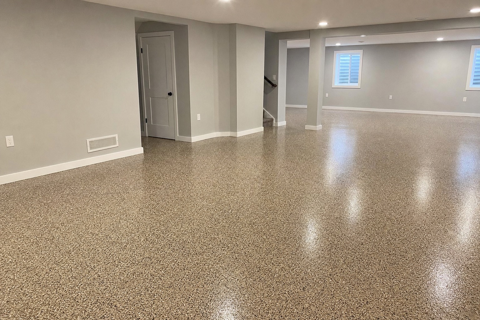 Finished basement with a tan decorative flake epoxy floor