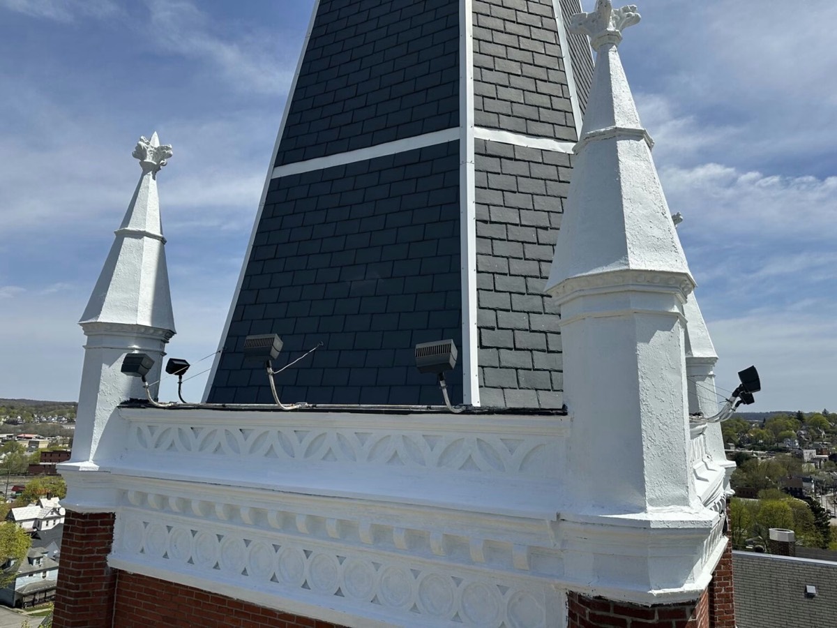 Restored church steeple with slate spire and stone pinnacles