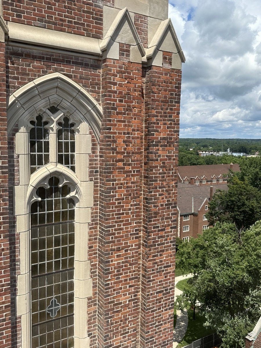 Gothic tower stone window tracery and brick repointing